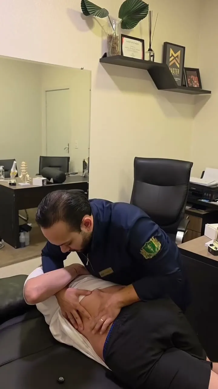 Dr. Giulian Saito atendendo um paciente na maca do consultório