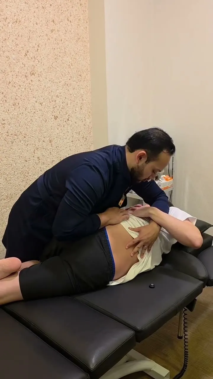 Dr. Giulian Saito fazendo uma manipulação de osteopatia na coluna de um paciente
